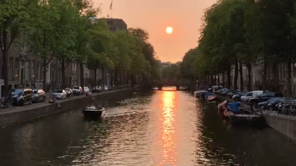 Un enorme tráfico de barcos de agua en el canal de agua en la ciudad de Ámsterdam al atardecer. Destino de viaje popular. Clima nublado. vídeo timelapse — Vídeo de stock