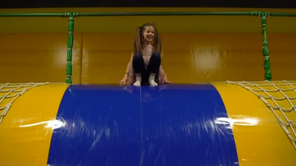 Menina contando e pulando na piscina seca com cubos macios. Criança planeta sala de jogos — Vídeo de Stock