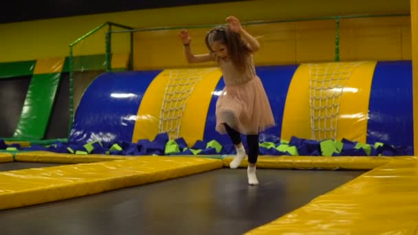 Liten flicka som hoppar på en studsmatta i lekrum för barnen — Stockvideo