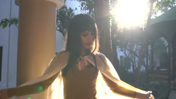 Schöne marokkanische Mädchen schwenkt ihren weißen Mantel in malerischen dar si sagte Riad in Marrakesch bei Sonnenuntergang — Stockvideo