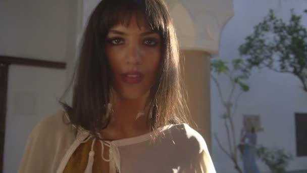 Bella ragazza marocchina che agita il suo manto bianco nella pittoresca Dar Si Said Riyad a Marrakech all'ora del tramonto — Video Stock