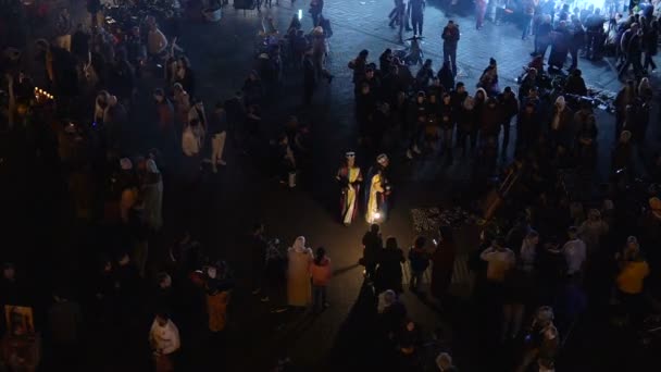 MARRUECOS - MARRAKECH ENE 2019: Vista nocturna de Djemaa el Fna, una plaza y mercado en el barrio de Marrakech medina. Street Berber Performanse en ropa tradicional — Vídeos de Stock