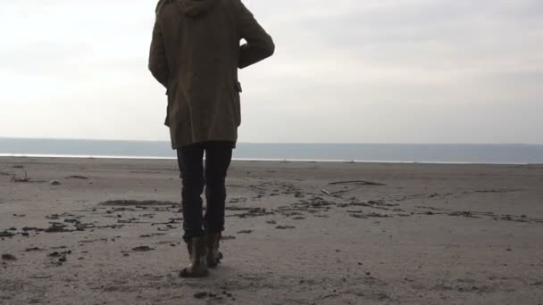 Young Stalker guy with rifle and painted face walking by footprints in cloudy post apocatyptic wasteland. Stalker - Survival concept — Stock Video