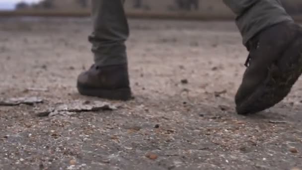 Piernas del hombre en zapatos pesados moutaineer caminando por el barro en el páramo nublado — Vídeo de stock