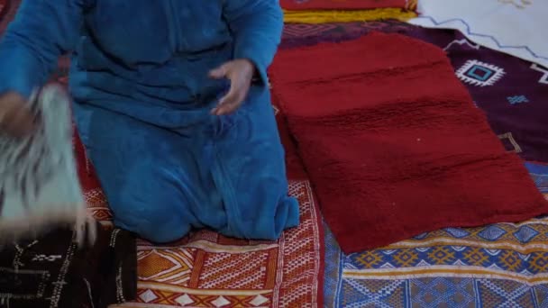 Marokkanische Frau zeigt ihre handgefertigten Teppiche im Haus, wo die Familie selbst gefertigte Teppiche herstellt — Stockvideo
