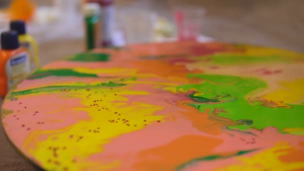 Close-up tiro de derramar decoração em uma pintura brilhante na sessão de terapia de arte. Tintas acrílicas pintura em tela redonda em cores brilhantes, dependendo do humor artistas — Vídeo de Stock