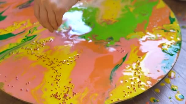 Close up shot of pouring decoration on a bright painting at Art therapy session. Acrylic dyes painting on round canvas in bright colors depending of the artists mood — Stock Video