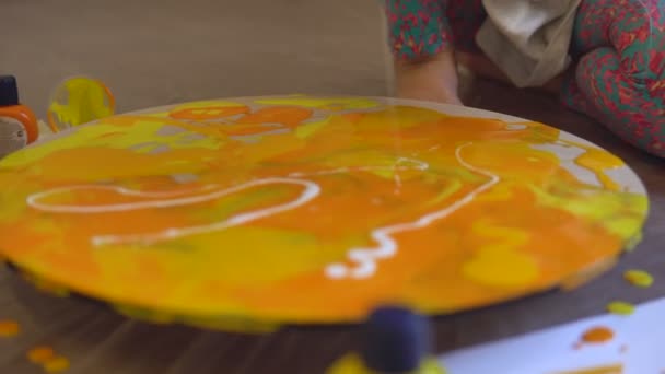 Närbild sköt av en ljus målning på Art Therapy session. Akryl färg ämnen målning på rund duk i ljusa färger beroende på konstnärer humör — Stockvideo