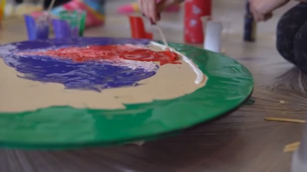 Primer plano de una pintura brillante en la sesión de terapia de arte. Pintura de tintes acrílicos sobre lienzo redondo en colores brillantes dependiendo del estado de ánimo del artista — Vídeo de stock