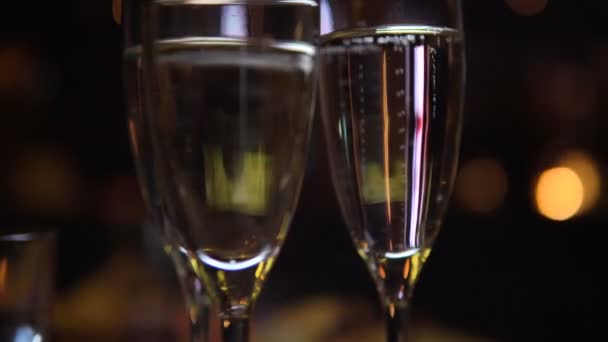 Champagne in glazen in nachtclub met feesten mensen op de achtergrond — Stockvideo
