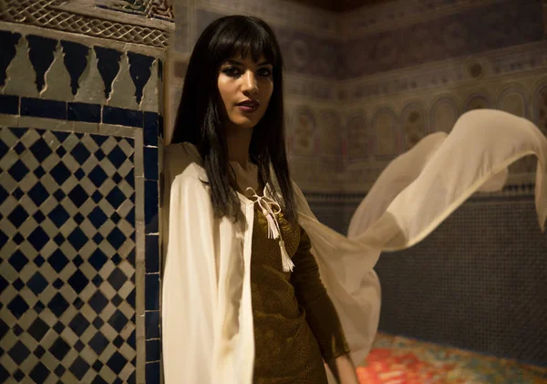 Hermosa chica marroquí en vestido corto de oro y capa de manto blanco en el rico interior de la pintoresca Dar Si Said Riyad en Marrakech — Foto de Stock