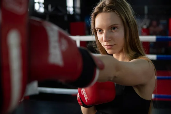 Blondes kaukasisches Kämpfermädchen, das aktiv zuschlägt. Üben in roten Boxhandschuhen — Stockfoto