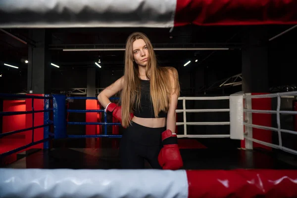Blondes kaukasisches Kämpfermädchen in roten Boxhandschuhen posiert auf dem Boxring des Kampfklubs — Stockfoto