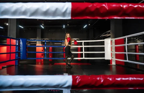 Blondes kaukasisches Kämpfermädchen in roten Boxhandschuhen posiert auf dem Boxring des Kampfklubs — Stockfoto
