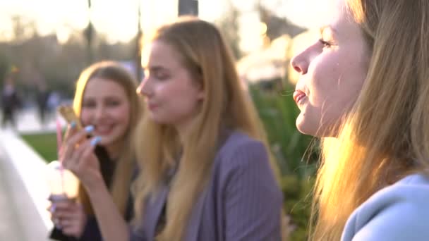 Üç kız arkadaş akşam broadway'de eğleniyor. Dondurma yemek, dondurma içme taze süt shake ve sakız çiğneme — Stok video
