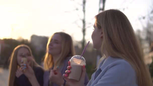 Tres amigas divirtiéndose en Broadway por la noche. Comer helado, beber helado, batido de leche fresca y goma de mascar — Vídeos de Stock