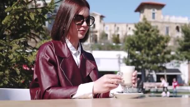 カフェの女の子 プールの近く晴れた日に日光の下でコーヒーラテを飲むカフェの美しい若い女性. — ストック動画