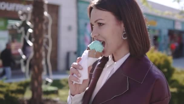ブロードウォークで歩き、晴れた日にアイスクリームを食べる愛らしいスタイリッシュなブルネットの女の子 — ストック動画