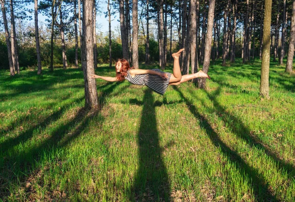 Young Red head woman levitating in the Pine forest — 스톡 사진