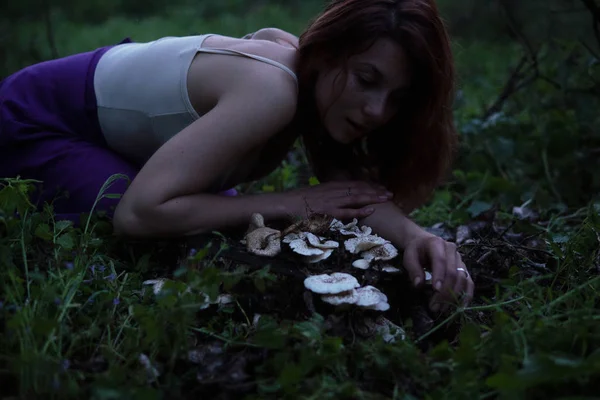 Jeune belle femme attrayant en jupe violette dans la forêt avec un champignon à Mysterious Twilight — Photo