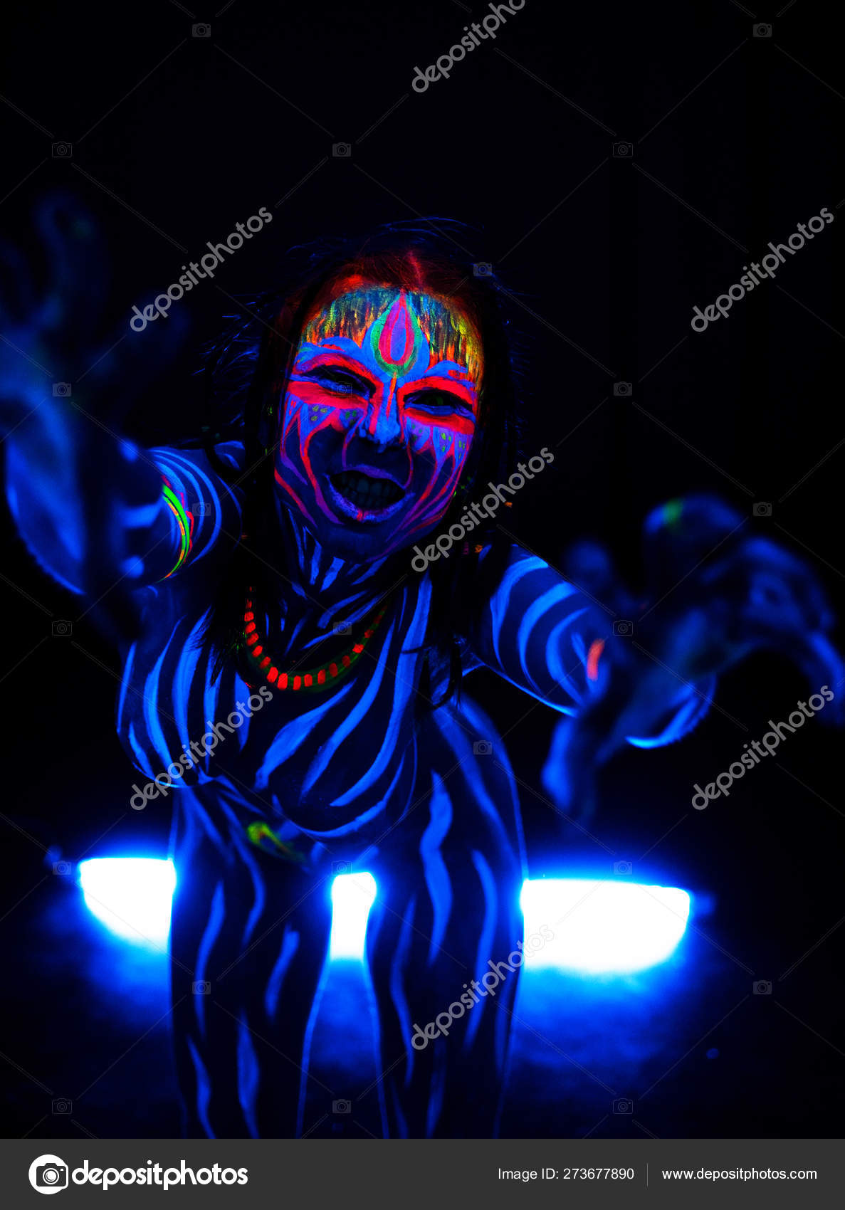 Portrait of Young naked bodyarted woman in blue glowing ultraviolet paint  with tomahawk ancient prehistorical weapon. Agressive avatar warrior   with pigtails hairstyle Stock Photo by ©tomasadzke 273678318