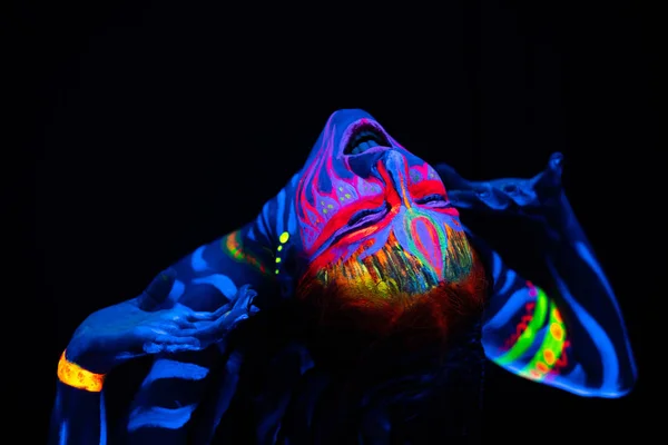 Mavi parlayan ultraviyole boya ve sarı göz lensler vahşi ve çılgınca genç çıplak bodyarted kadın yakın yukarı portre. Pigtails saç modeli ile avatar varlığı Amazon savaşçı kız