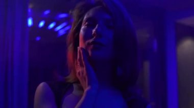 Siyah kokteyl elbise dans ve yanıp sönen Neon ışık ile özel ev parti üzerinde genç güzel kadın.