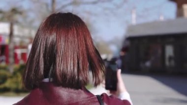 Lüks güzel kadın sokakta yürüyüş ve telefonu ile video kayıt