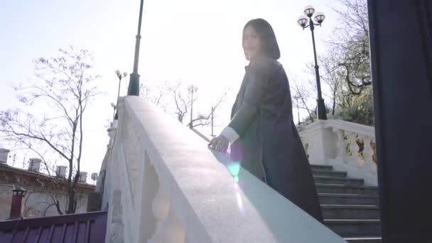Brunetka žena chůze po schodech na slunném Broadwayi. — Stock video