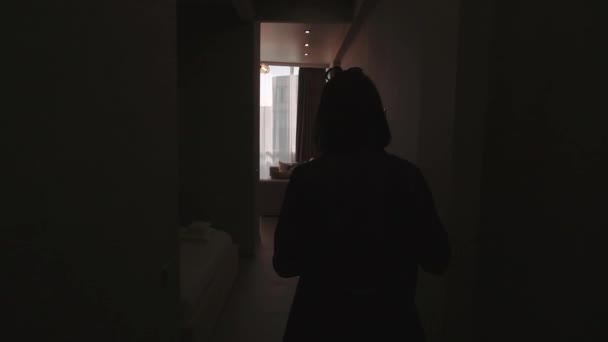 Urocza stylowa dziewczyna brunetka zbliża się do jej nowych mieszkań, przechodząc korytarz i przychodzi do okna z pięknym widokiem — Wideo stockowe
