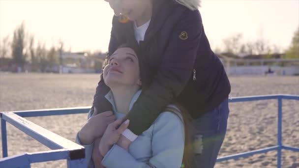 Familie vrije tijd. Jonge gehandicapte vrouw in rolstoel met haar moeder wandelen in de buurt van de zee op de oprit voor mensen met een handicap — Stockvideo