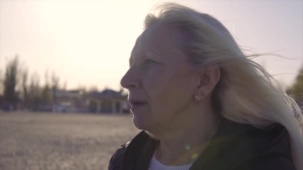 Familie vrije tijd. Jonge gehandicapte vrouw in rolstoel met haar moeder wandelen in de buurt van de zee op de oprit voor mensen met een handicap — Stockvideo