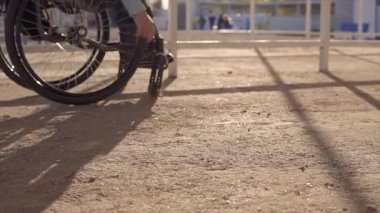 Akşam sonbahar veya ilkbahar aylarında engelliler için bölgede sahilde dinlenen tekerlekli sandalyeli genç engelli kadın