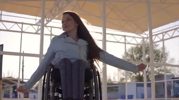 Jeune femme handicapée en fauteuil roulant se reposant sur la plage dans la région pour les personnes handicapées au soir automne ou printemps — Video