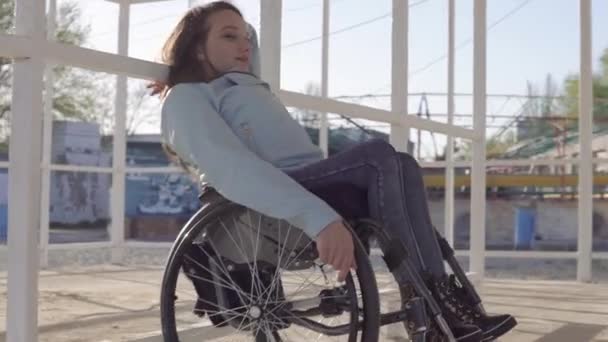 Fiatal fogyatékos nő tolószékben pihenő a strandon a fogyatékkal élők számára az esti őszi vagy tavaszi idő — Stock videók