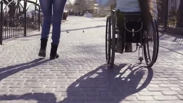 Loisirs en famille. Jeune femme handicapée en fauteuil roulant avec sa mère marchant près de la mer, parlant et s'amusant — Video