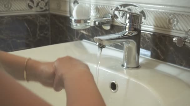 Den lilla barnflickan tvättar händerna med gyllene armband — Stockvideo