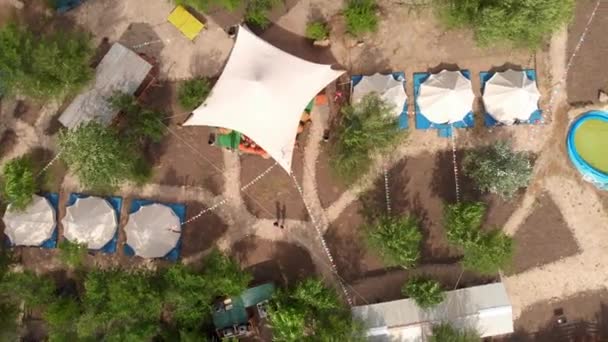 Bovenaanzicht van de luchtfoto van de luxe camping met grote witte tenten en feestzalen, gestileerde gebieden, paden en kampeer activiteiten — Stockvideo