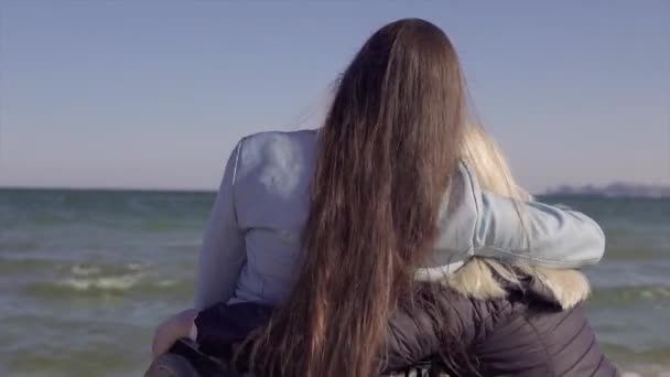 Νεαρή γυναίκα με ειδικές ανάγκες σε αγκαλιές αναπηρικής πολυθρόνας με τη μητέρα της κοντά στη θάλασσα — Αρχείο Βίντεο