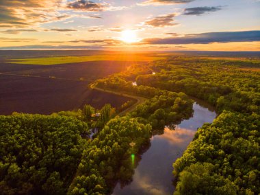 Sunset River havadan peyzaj sinematik drone görüntüleri. Çevresinde ormanlar ve tarlalar ile Ukrayna veya Moldova 'da Dniestr Nehri üzerinde uçan