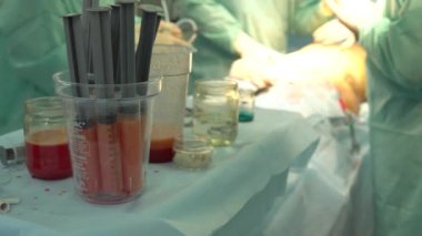 Şırıngalı bir cerrahın elleri, enjektör. Cerrah doktorlar grubu cerrahi odada lipofilling yapıyor