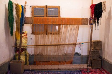 Tinghir, Fas'taki Atlas dağlarında özelleştirme aile üretiminde, bir dokuma tezgâhı üzerinde geleneksel tekniklerle halı dokuma için eski stil araç