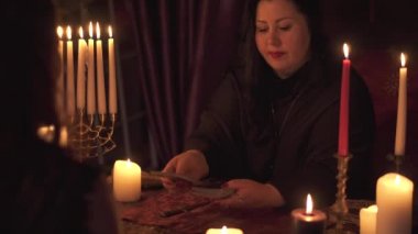 Bir tarot kart güvertede mumlar çok karanlık odada Falcı kadın tahmin