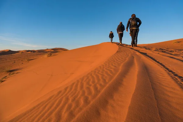 Drie wandelliefhebbers zijn goiong op de zandduin in erg Chebbi Desert, Marokko — Stockfoto