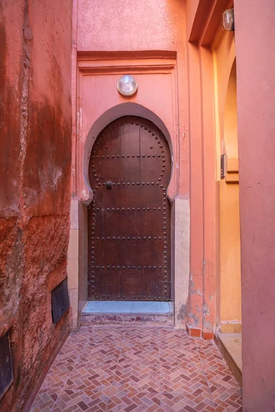 Παραδοσιακό μαροκινό στυλ Design μιας αρχαίας ξύλινης πόρτας εισόδου. Στην παλιά Μεντίνα στο Μαρακές του Μαρόκου. Τυπικό, παλιό, καφέ περίπλοκα σκαλιστά, με καρφιά — Φωτογραφία Αρχείου