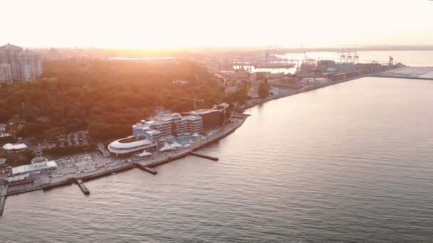 Pemandangan panorama udara dari pantai dan kota modern yang indah saat matahari terbenam di langit pada musim panas. Port Odessa — Stok Video