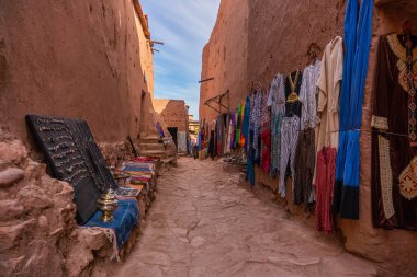 Fas'ta sahra çölü kenarında Ouarzazate yakınlarındaki Ait ben Haddou müstahkem kasabasında Sokaklar. Atlas dağları. Mal ve halı ile Sokak yerel etnik pazar