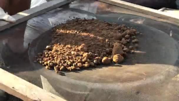 Крупним планом знімок просіювання через суху глину для будівництва простого будинку з авіацегли adobe — стокове відео
