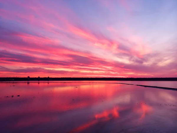 Aerial view of drone shot over water surface in twilight, golden hour sunset. Amazing view, firth surface reflecting majestic red and pink clouds — Stock Photo, Image