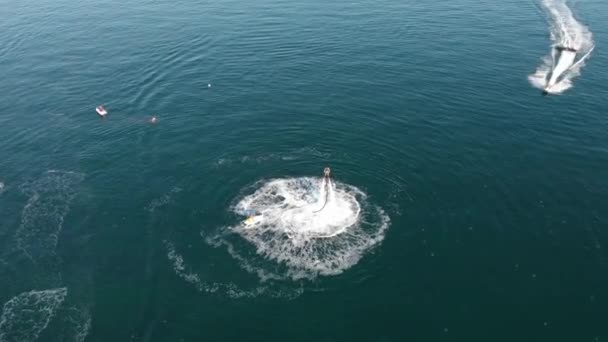 Ucraina, Odessa - Agosto 2019: Aerial Quadcopter View Over Young Man Riding A Jet Ski Flyboard In Sea Clear Blue Water Extreme Sports Vacation Summer Getaway Concept Hot Summer Day — Video Stock